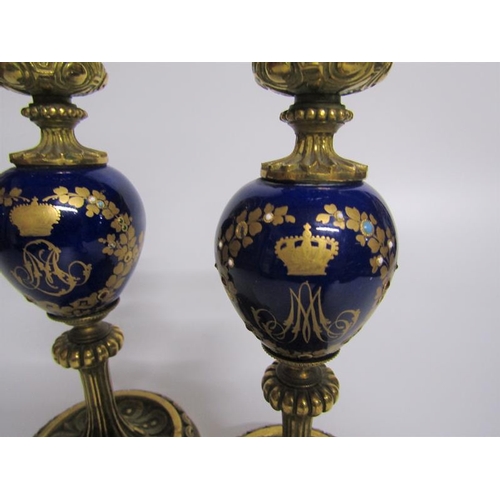 63 - A pair of late 19c ormolu and ceramic candlesticks, the ceramic knops with jewelled gilt wreath desi... 