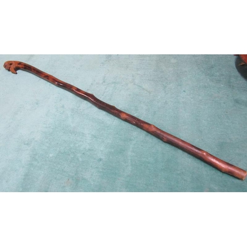 98 - An Oriental walking stick with carved mask handle.  94cms l.