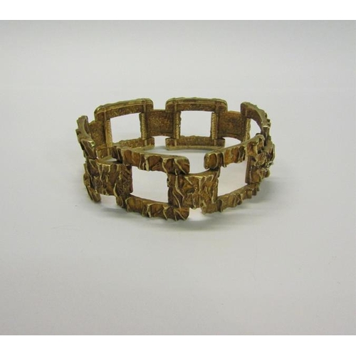 197 - An 1950s 9ct gold bracelet of large square link design with bark texture - 61g.