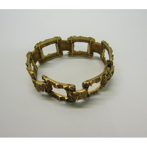 197 - An 1950s 9ct gold bracelet of large square link design with bark texture - 61g.