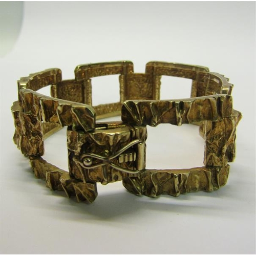 197 - An 1950s 9ct gold bracelet of large square link design with bark texture - 61g.