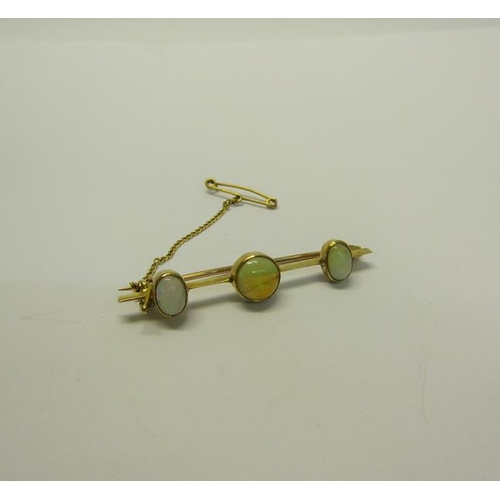 201 - A gold three stone Opal set bar brooch - 4.5cms l.