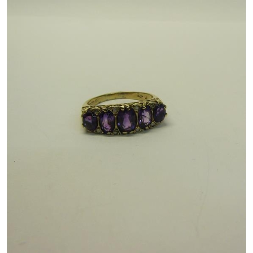 210 - A gold five stone ring set with five cut Amethysts.  Ring size P/Q.