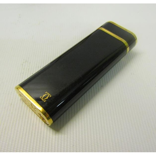 120 - A Cartier of Paris Plaque lighter or G28407V with black enamel and gilt case.  In original box.