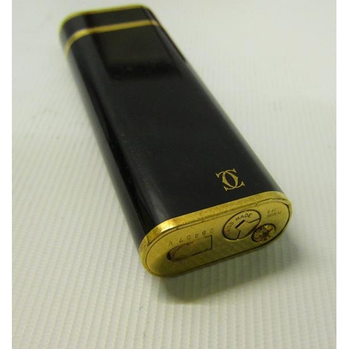 120 - A Cartier of Paris Plaque lighter or G28407V with black enamel and gilt case.  In original box.