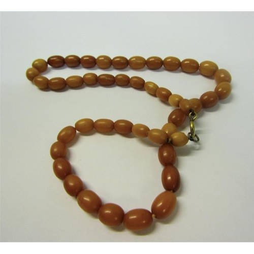 157 - A string of forty five butterscotch amber beads of graduated size.  44cms l.  Total weight 14.3g.