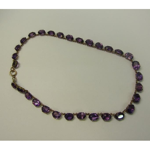 166 - A late 19/early 20c gold Amethyst set Riviere necklace set with twenty one graduated cut stones.  40... 