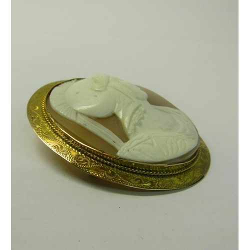 168 - A Greek warrior cameo brooch of oval form set in a 9ct gold engraved mount.  5cms w.