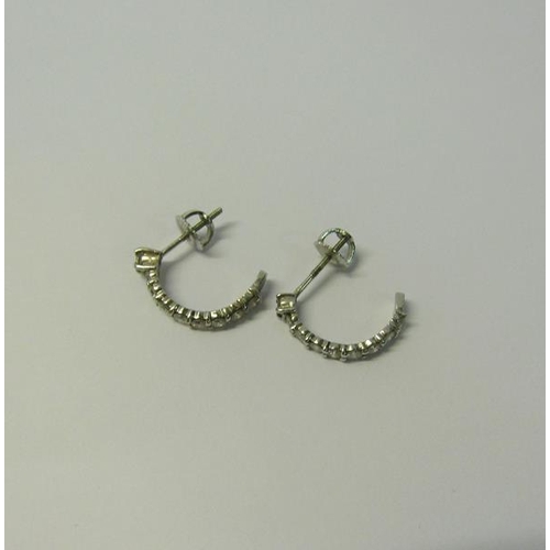 173 - A pair of 18ct white gold and Diamond set half hoop earrings.