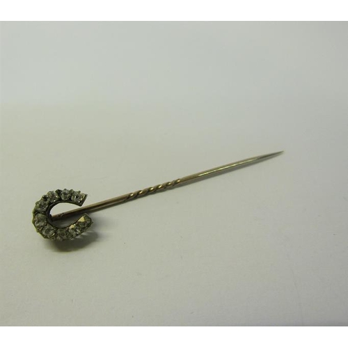 189 - A gold stick pin set with gold Diamond horseshoe.  5.5cms l.