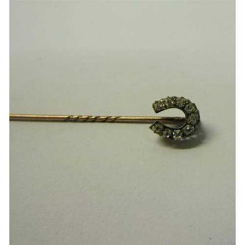 189 - A gold stick pin set with gold Diamond horseshoe.  5.5cms l.