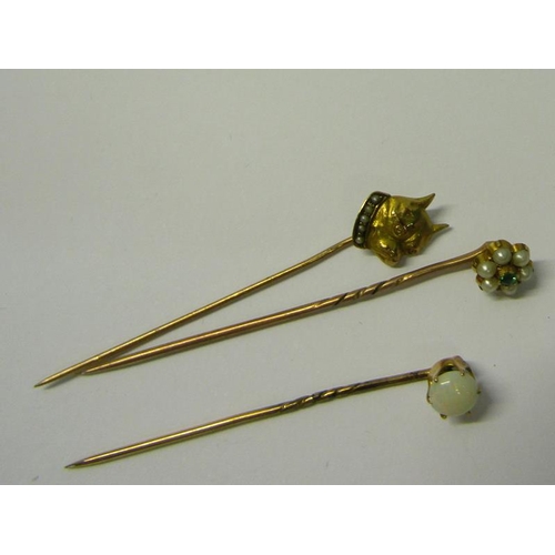 190 - A collection of three gold stick pins, one set with Emerald and Seed Pearl, one set Opal, the other ... 