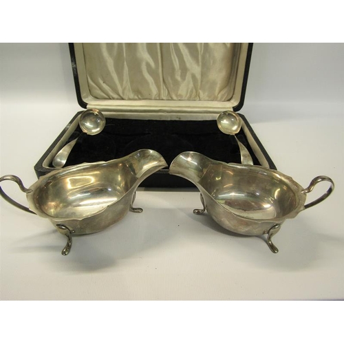 269 - A pair of silver sauce boats together with ladles of late Georgian design with shaped upper rims, sc... 