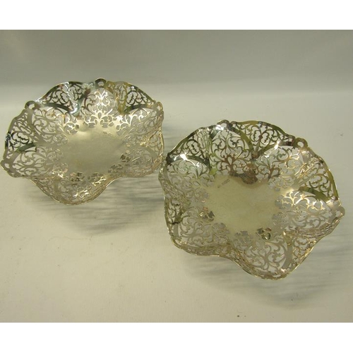 274 - A pair of silver pierced dishes with wavy edge supported on three legs.  Makers mark for Douglas Hea... 