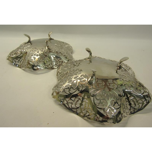 274 - A pair of silver pierced dishes with wavy edge supported on three legs.  Makers mark for Douglas Hea... 