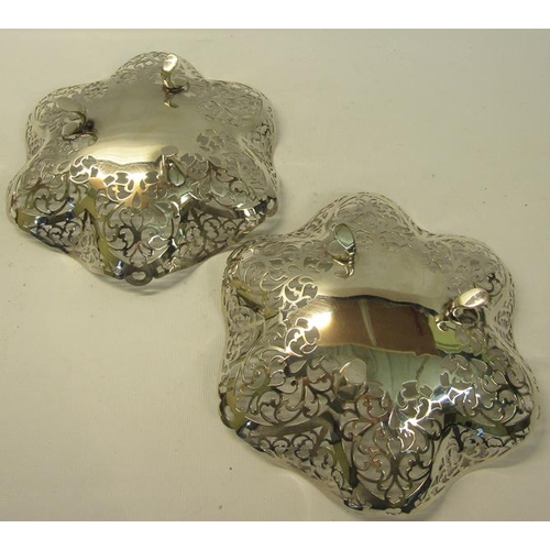 274 - A pair of silver pierced dishes with wavy edge supported on three legs.  Makers mark for Douglas Hea... 