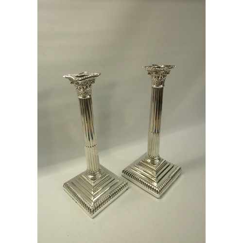 285 - A pair of Edwardian silver column candlesticks on square stepped gadrooned bases, with fluted column... 