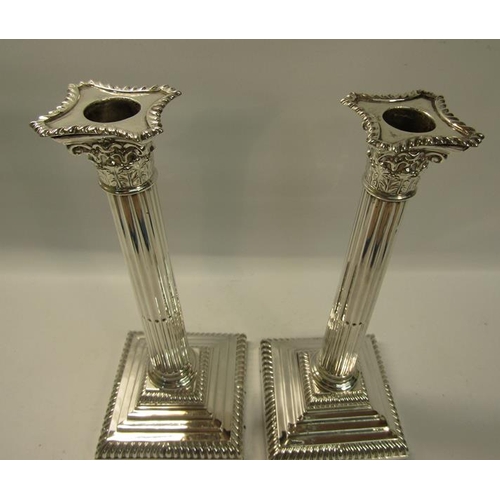 285 - A pair of Edwardian silver column candlesticks on square stepped gadrooned bases, with fluted column... 