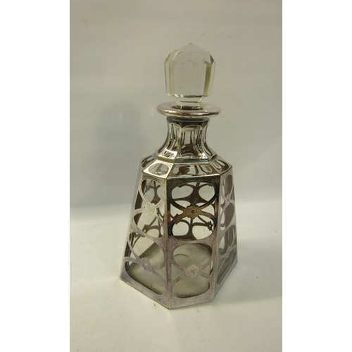 288 - An early 20c clear glass hexagonal facet tapering decanter, silver cased with open ovals and flower ... 