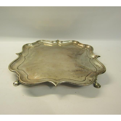 302 - An Edwardian silver salver of quatrefoil form with raised shape border supported on four hoofed feet... 