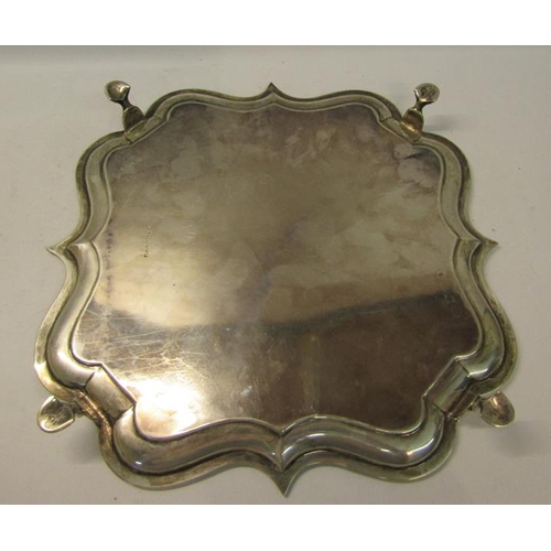 302 - An Edwardian silver salver of quatrefoil form with raised shape border supported on four hoofed feet... 