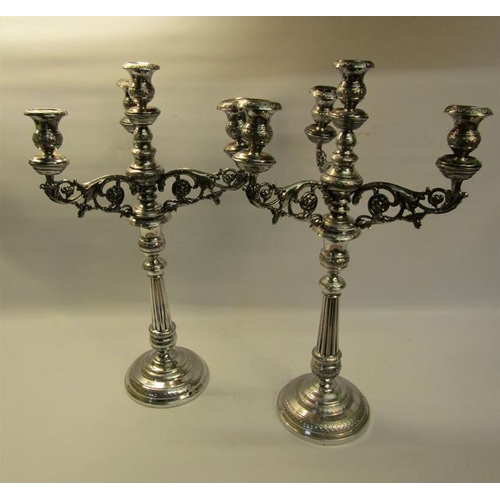 303 - A pair of 19c silver three branch candelabra's with knot fluted tapering columns and raised on stepp... 