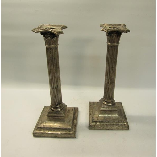 305 - A pair of silver Corinthian column candlesticks, makers marks are rubbed.  London 1910.  The base is... 