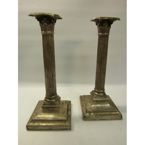 305 - A pair of silver Corinthian column candlesticks, makers marks are rubbed.  London 1910.  The base is... 