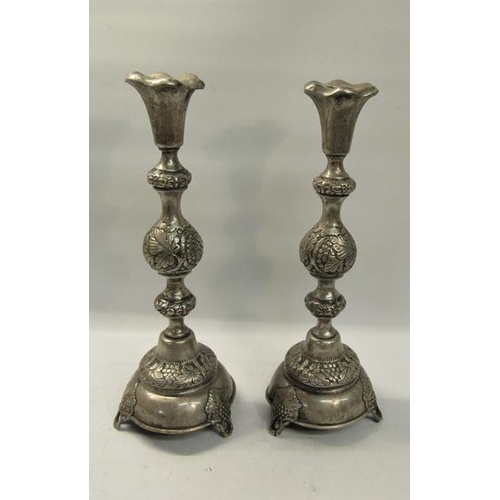 309 - A pair of 19c Russian silver candlesticks with embossed double knop columns on circular stepped base... 