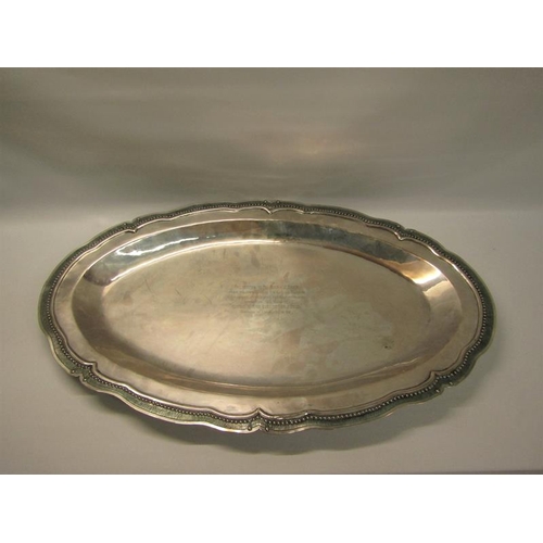 311 - A South American silver oval dish with a raised beaded and incised shaped border.  62cms w.  54ozt