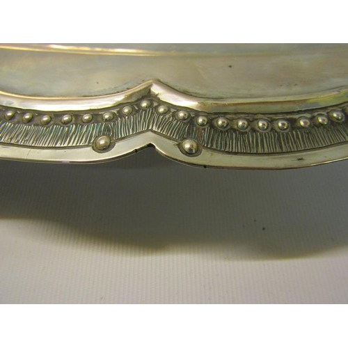 311 - A South American silver oval dish with a raised beaded and incised shaped border.  62cms w.  54ozt