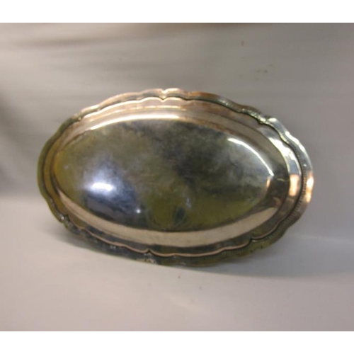 311 - A South American silver oval dish with a raised beaded and incised shaped border.  62cms w.  54ozt