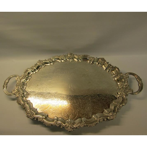 313 - A late Victorian two handled silver tea tray with a raised shaped border cast with leaf and shell, t... 