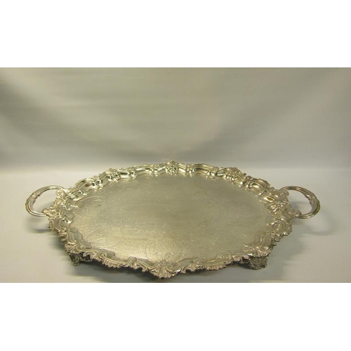 313 - A late Victorian two handled silver tea tray with a raised shaped border cast with leaf and shell, t... 