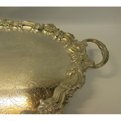 313 - A late Victorian two handled silver tea tray with a raised shaped border cast with leaf and shell, t... 