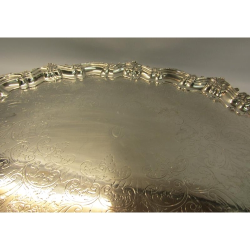 313 - A late Victorian two handled silver tea tray with a raised shaped border cast with leaf and shell, t... 