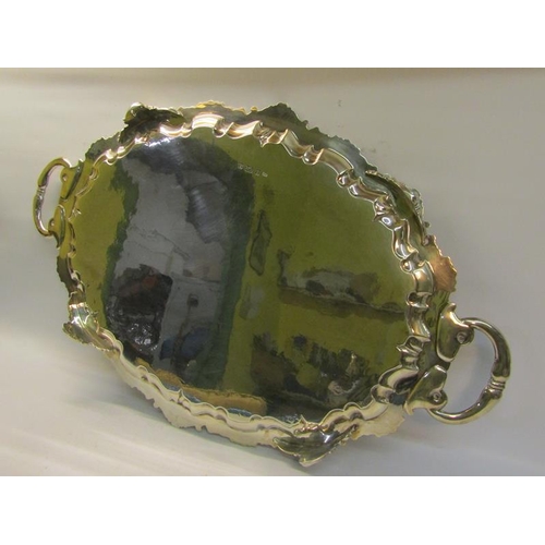 313 - A late Victorian two handled silver tea tray with a raised shaped border cast with leaf and shell, t... 