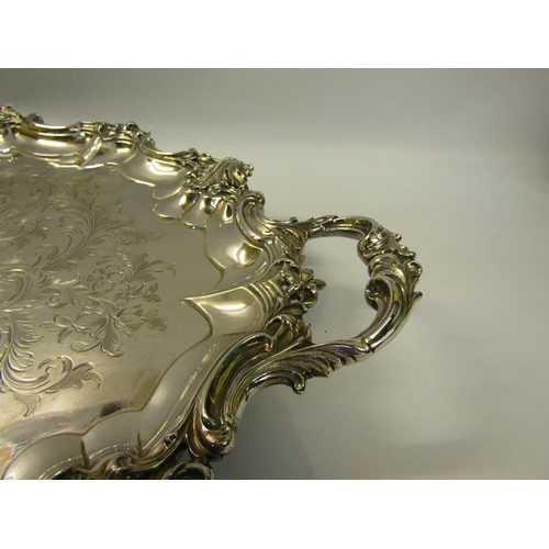 316 - A mid Victorian silver two handled tray with a raised and shaped leaf and scroll formed border, chas... 