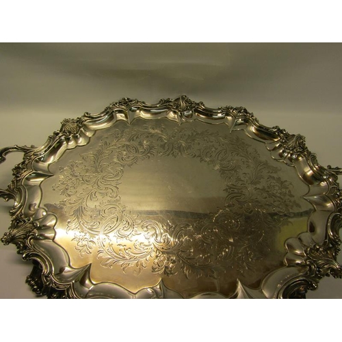 316 - A mid Victorian silver two handled tray with a raised and shaped leaf and scroll formed border, chas... 