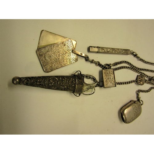 226 - A late Victorian silver chatelaine with five chains, carrying a silver pencil, a vesta case, a stamp... 