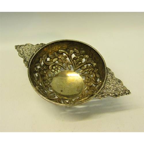 228 - A George III silver quaich shaped bowl, pierced and floral embossed and chased with two side handles... 