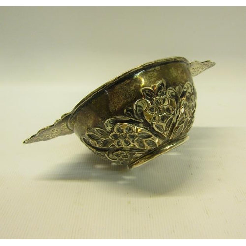 228 - A George III silver quaich shaped bowl, pierced and floral embossed and chased with two side handles... 