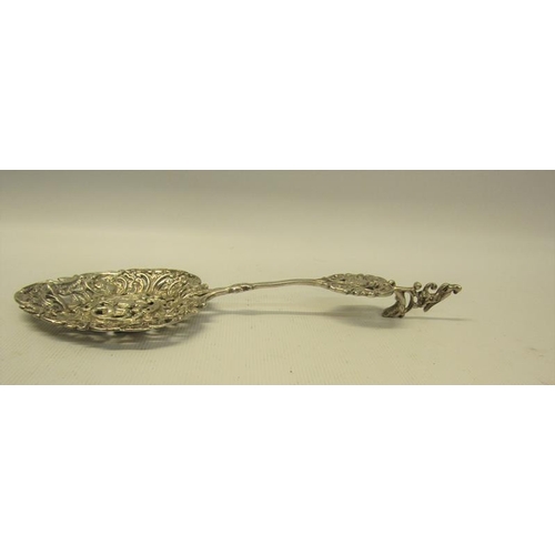 234 - A late Victorian silver decorative tablespoon with cast and pierced ovoid bowl, with terminal rest. ... 