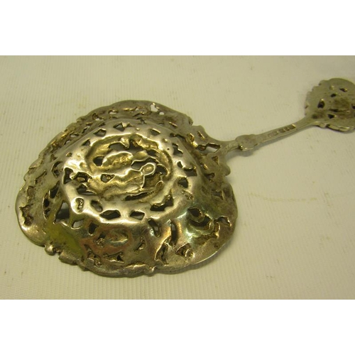 234 - A late Victorian silver decorative tablespoon with cast and pierced ovoid bowl, with terminal rest. ... 