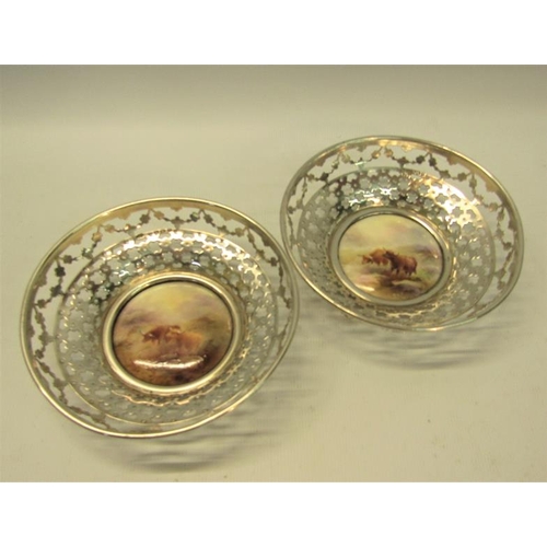 237 - A pair of circular silver bowls, pierced and with James Stinton Royal Worcester bases, both decorate... 