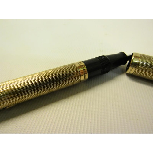 104 - A Waterman 9ct gold engine turned fountain pen.  13.5cms l.