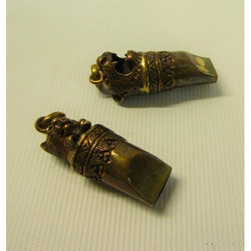 108 - A pair of Victorian gilt copper and brass dog whistles, one with a cat wearing a bow terminal, the o... 