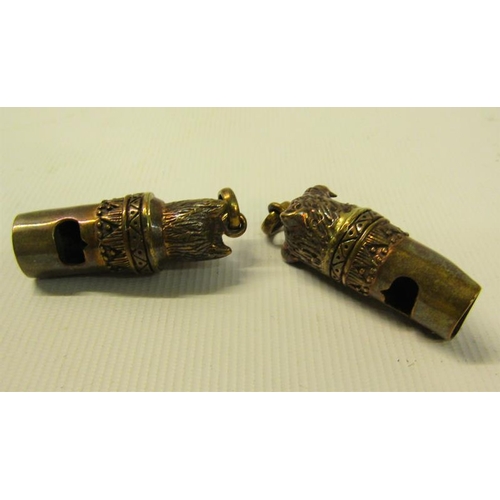 108 - A pair of Victorian gilt copper and brass dog whistles, one with a cat wearing a bow terminal, the o... 