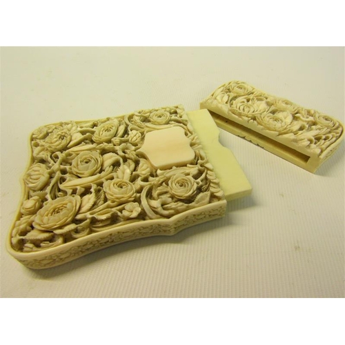 115 - A late 19c ivory card case carved in high relief with panels of leaf and flowers, and through the re... 