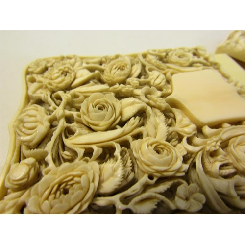 115 - A late 19c ivory card case carved in high relief with panels of leaf and flowers, and through the re... 